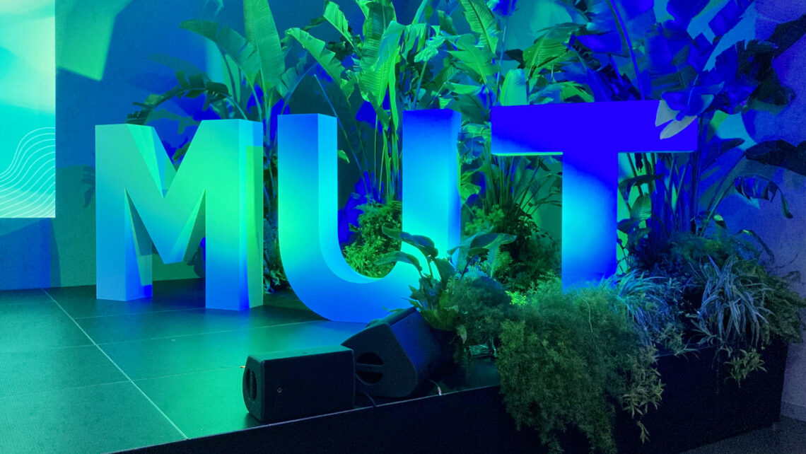 diesige 3D Buchstaben "Mut" stehen auf einer Bühne und sind blau Grün beleuchtet